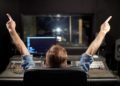 man at mixing console in music recording studio