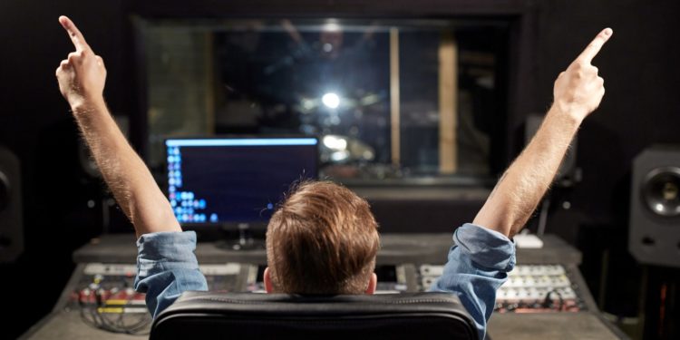 man at mixing console in music recording studio