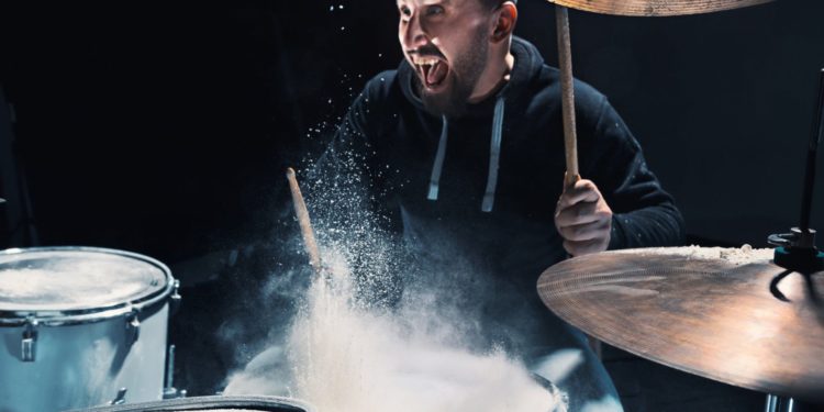 Drummer rehearsing on drums before rock concert. Man recording music on drum set in studio